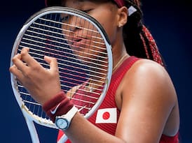 Naomi Osaka checking strings on racket